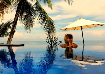 Kracht van kleur - Katrín kijkt vanuit zwembad over de turquoise zee van Bali
