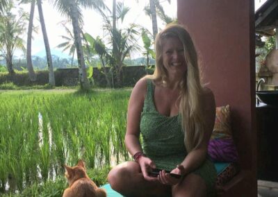 Kracht-van-Kleur-Katrín-in-groene-jurk-zit-met-rode-kat-bij-de-rijstvelden-in-Ubud-op-Bali-klein